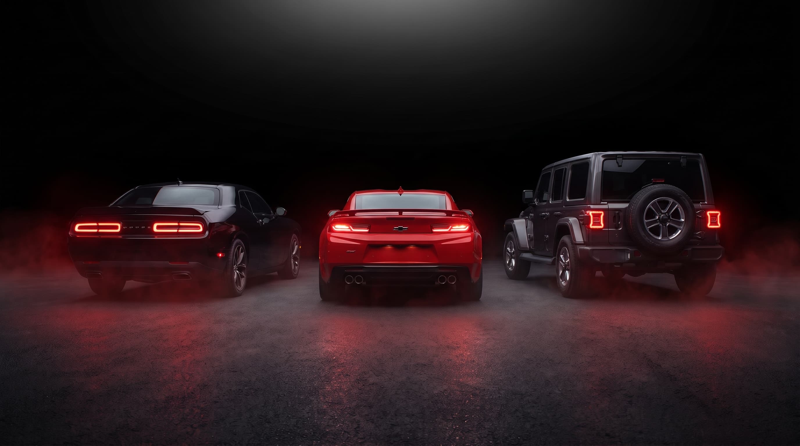 Camaro, Challenger y Wrangler de espaldas con las calaveras encendidas